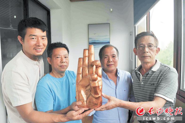 ←昨日,龙跃平(右二)决定将自己的雕塑《种子》模型捐赠给隆平水稻博物馆。均为长沙晚报记者 贺文兵 摄